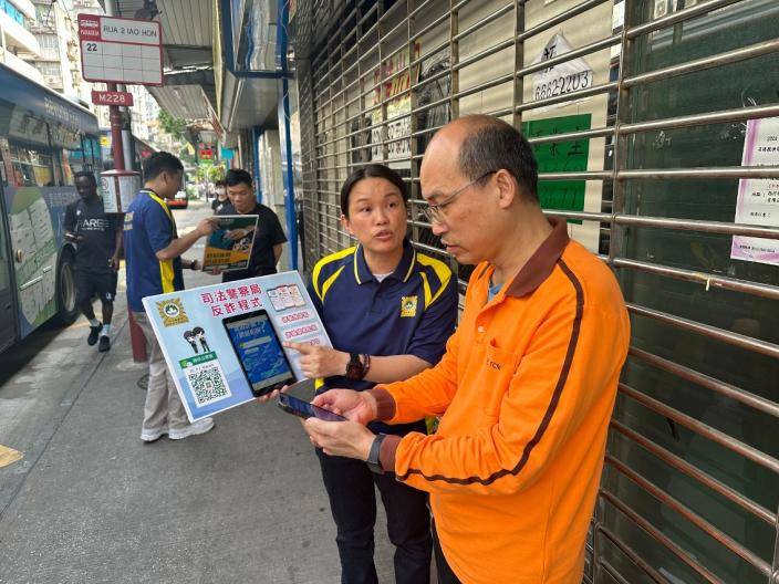 司警局人員向市民介紹反詐程式。澳門政府新聞局圖片